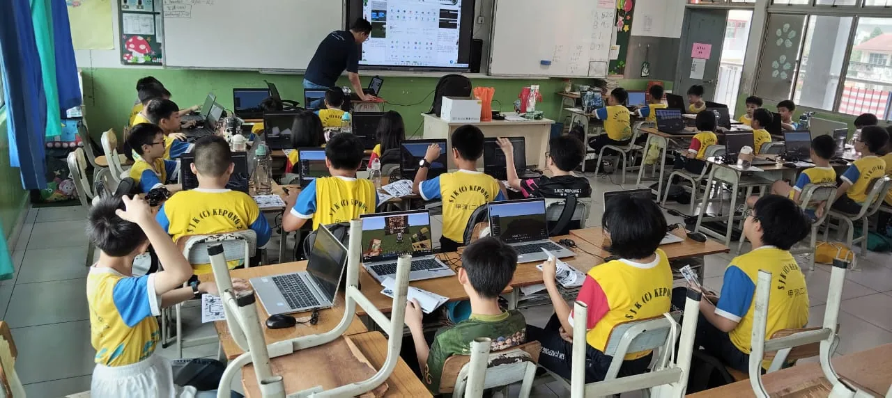 Children using laptops while an educator guides the holiday class at SJK(C) Kepong 2
